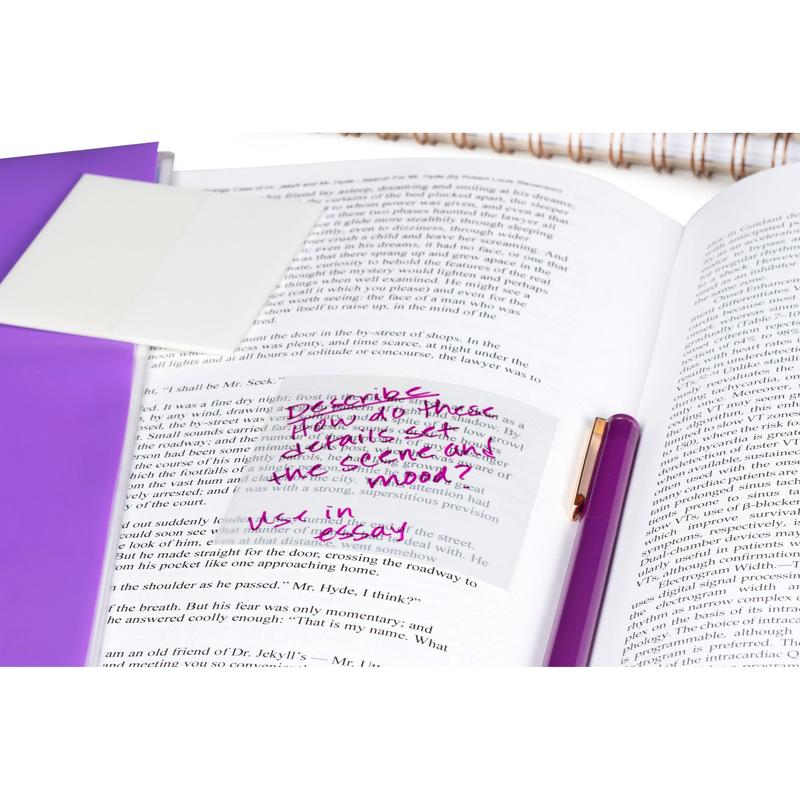 An open book with handwritten notes on a 73 mm x 73 mm Post-it® Transparent Note (36 sheets, 12 pads/package) from 3M Deutschland GmbH. Next to it are a purple pen, a folder, and a spiral notebook in the background.