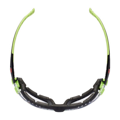The 3M™ Solus™ Safety Glasses 1000 from 3M Deutschland GmbH feature a clear lens, a black and neon green frame, a cushioned foam gasket, and curved temples. In the top view, the Scotchgard™ coated safety glasses highlight their lining.