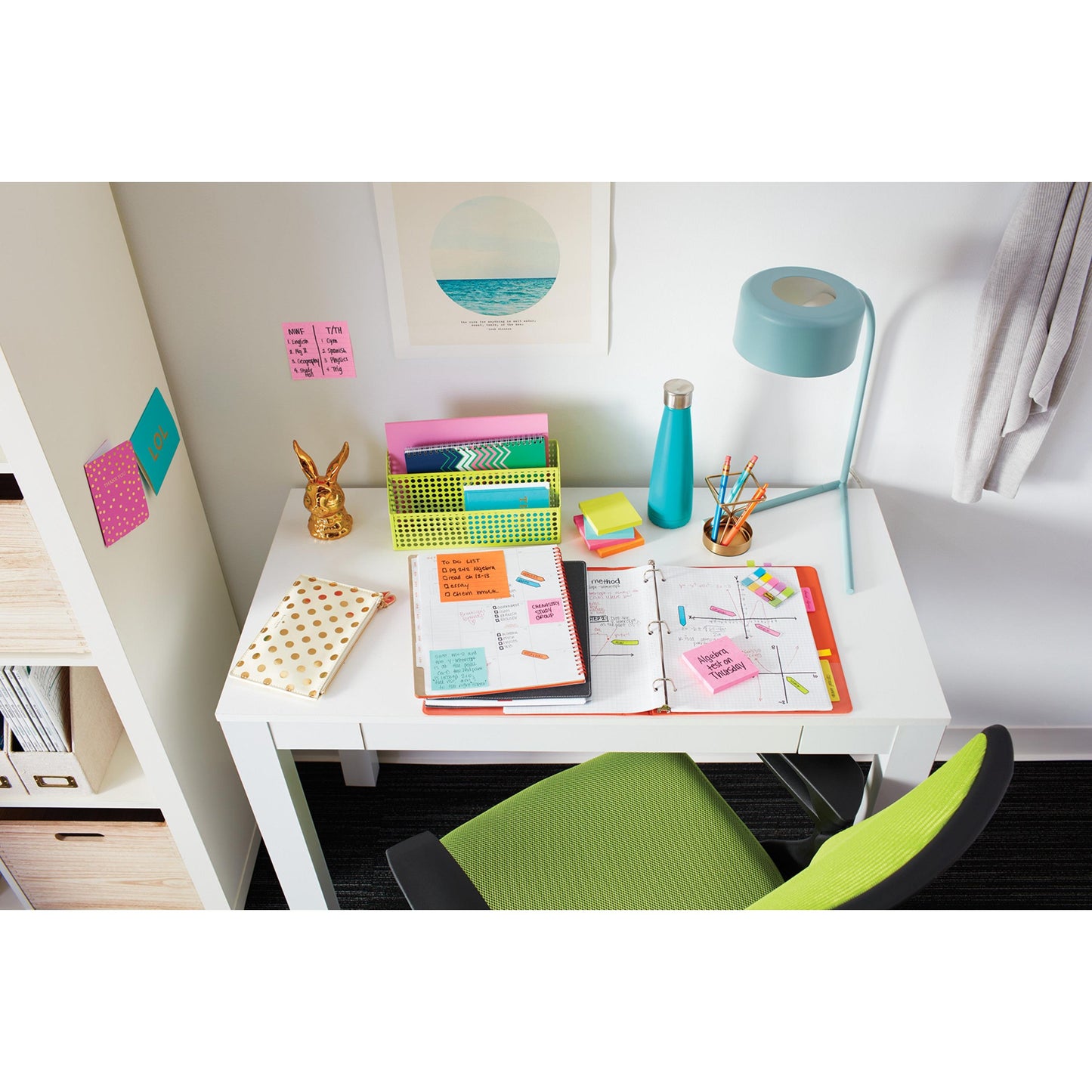 A white desk with an open binder, notebooks, pens, a lamp, a water bottle, and a golden rabbit-shaped holder. In front is a green chair, and colorful Post-it® Notes from 3M Deutschland GmbH are stuck on the wall.