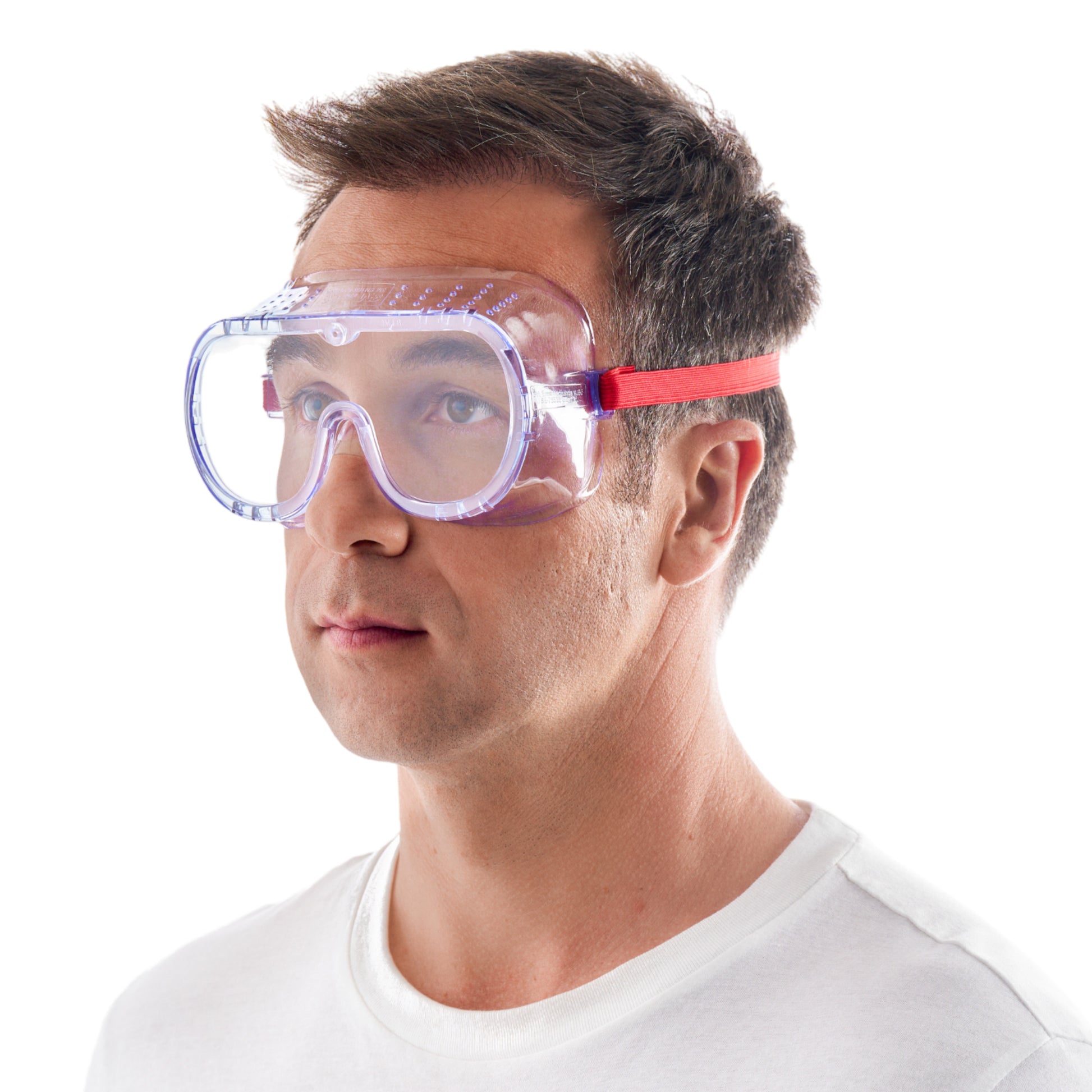 Ein Mann in einem schlichten weißen Hemd trägt die 3M™ Classic Schutzbrille 4700 (direkt belüftet, Klarsichtscheibe) der 3M Deutschland GmbH mit klaren Gläsern und rotem Gummiband und blickt leicht nach oben vor einem weißen Hintergrund.