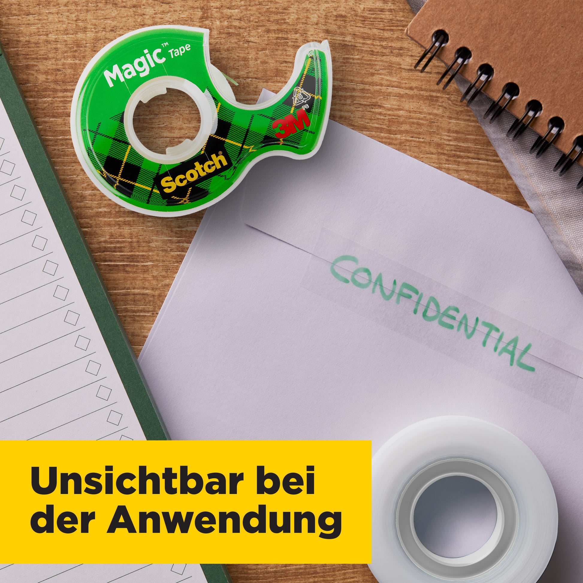 Auf dem Schreibtisch liegen ein 3M Scotch® Magic™ Unsichtbares Klebeband Nachfüllpack (2 Rollen, 19 mm x 7,5 m), ein Notizbuch, ein Notizblock und ein Umschlag mit der Aufschrift "VERTRAULICH". Auf einem gelben Transparent steht in deutscher Sprache: "Unsichtbar bei der Anwendung.