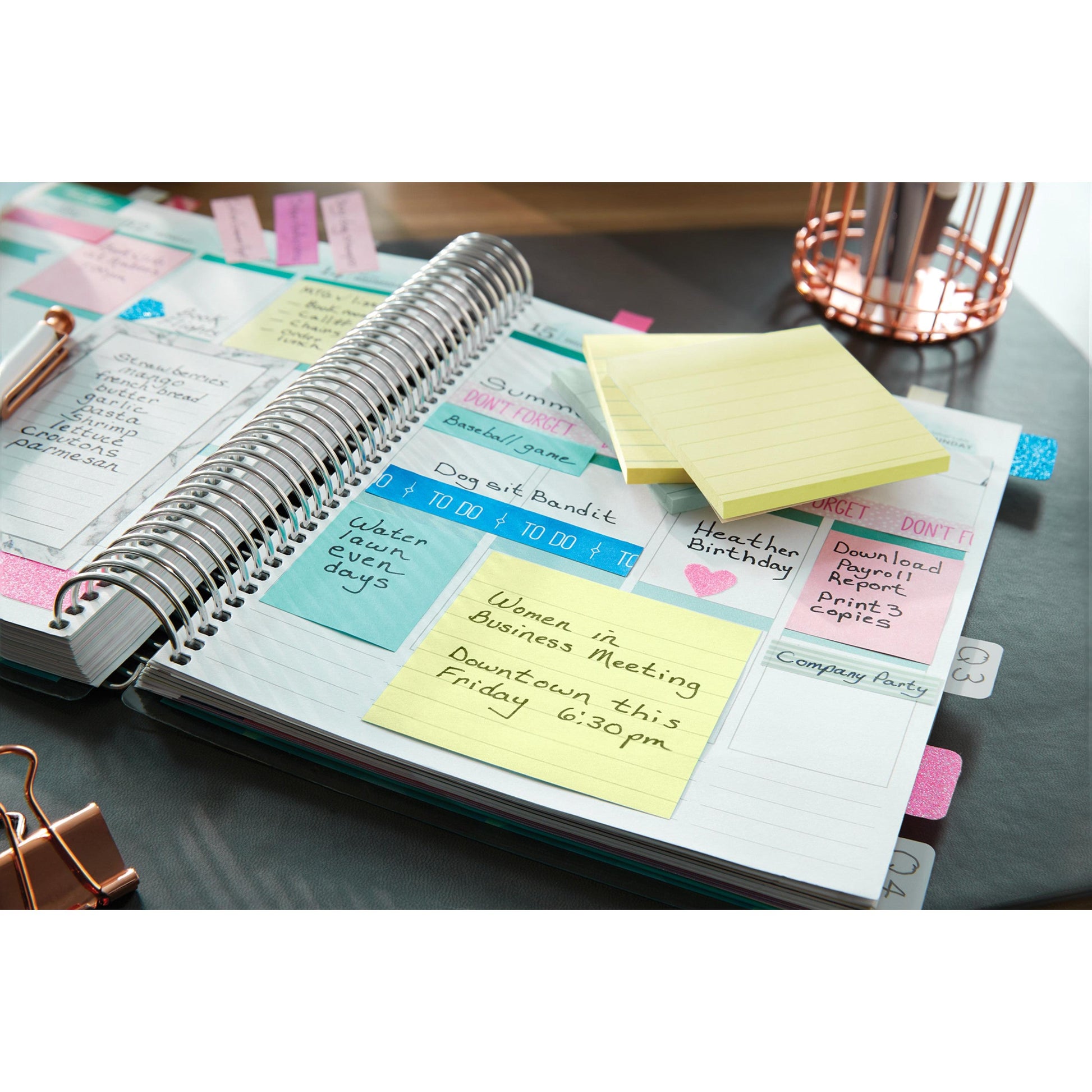 Ein offener Planer mit Notizen, Erinnerungen und einem gelben 3M Post-it® Notes im Großformat (101 mm x 152 mm) der 3M Deutschland GmbH ist das Highlight eines "Women in Business Meeting" am Freitag um 18:30 Uhr in der Innenstadt. Stifte und ein Draht-Organizer liegen bereit.