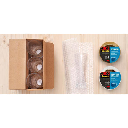 Four glass cups in a box, bubble wrap, and two rolls of Scotch® Extra Strong Packaging Tape (3M Deutschland GmbH, transparent, 48 mm x 20 m) are arranged on a light wooden surface.