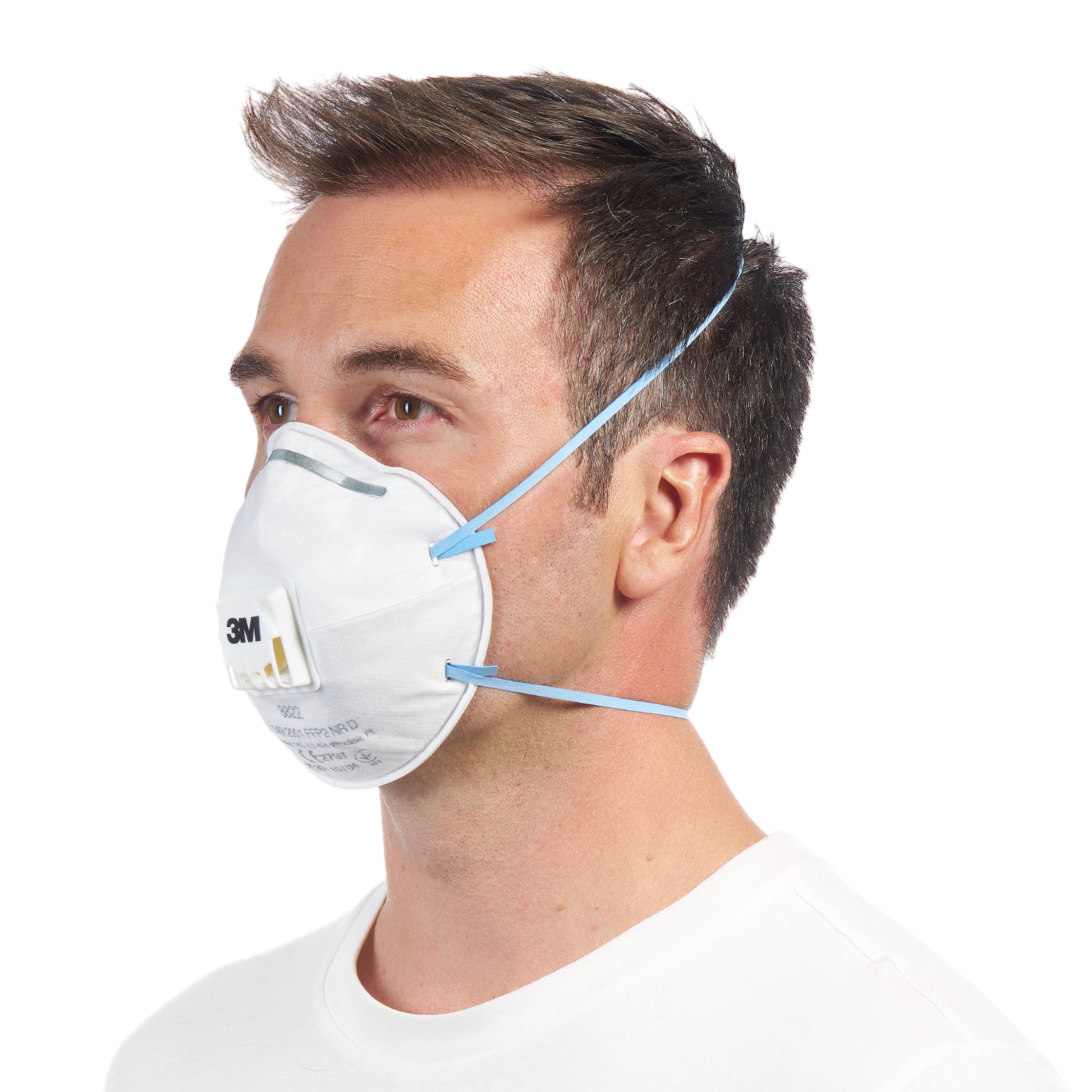 Eine Person in einem schlichten weißen Hemd trägt eine 3M™ Cool Flow™ Partikelmaske 8822 FFP2 mit Ventil der 3M Deutschland GmbH, mit blauen elastischen Bändern und nach links gerichtet.